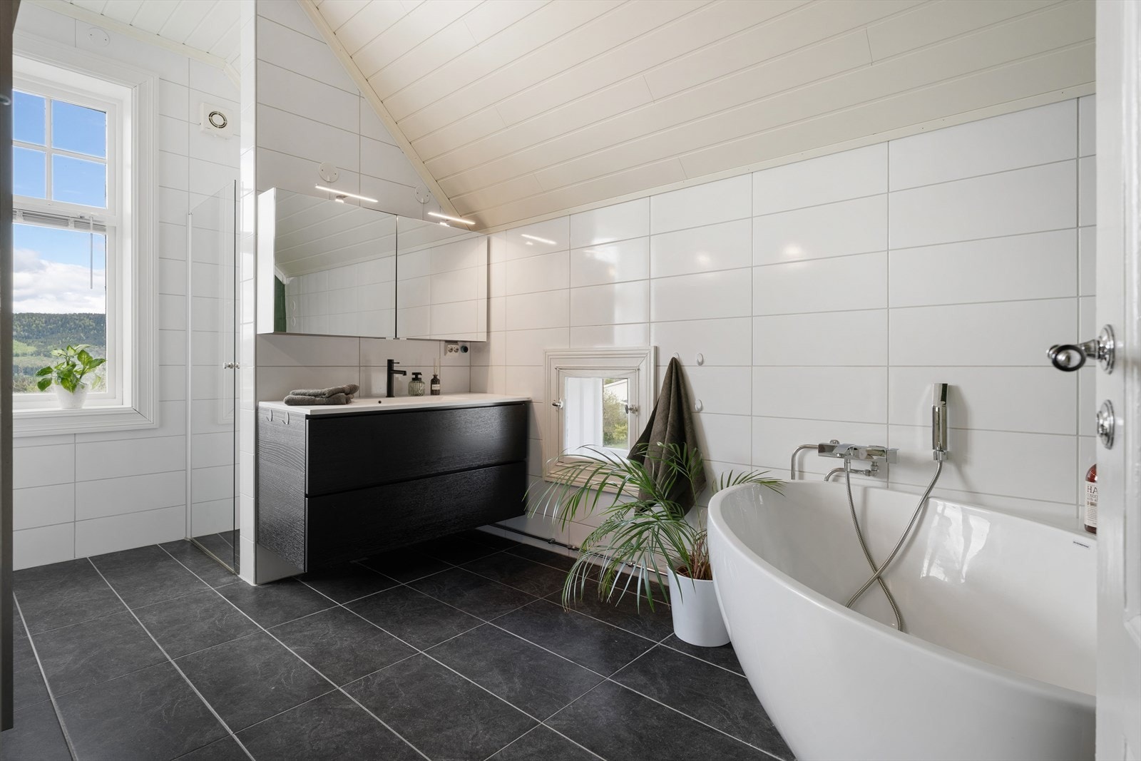 Et av to bad i andre etasje. Lyst og lett, med do, badekar og separat dusjnisje. Galleribilde