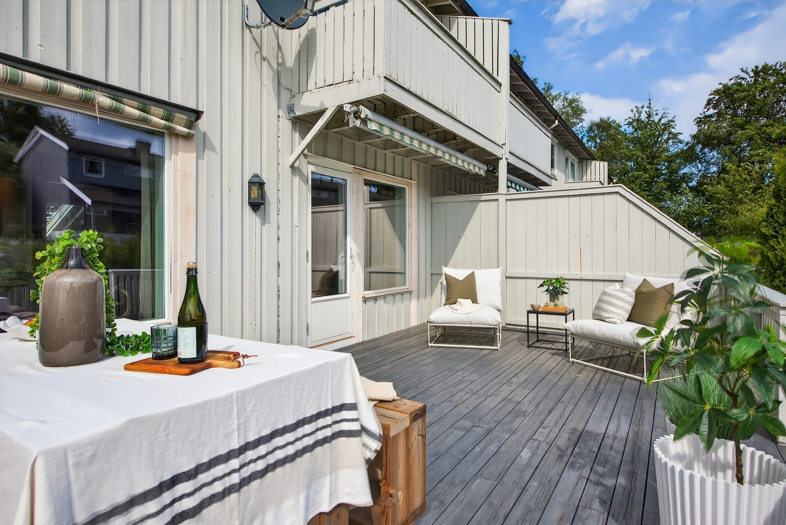 Terrassen har god plass til både spisebord og loungemøbler - ideell for både måltider og avslapning i solen Galleribilde
