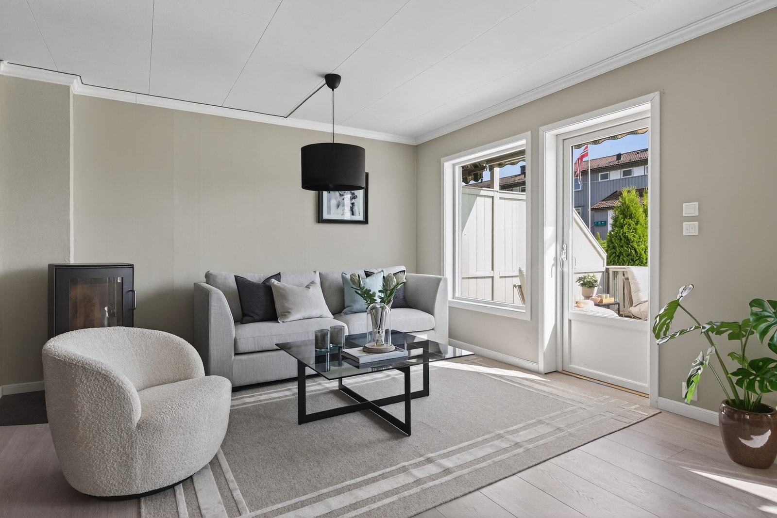 Et lyst og åpent oppholdsrom med lune farger og rikelig med naturlig lys Galleribilde