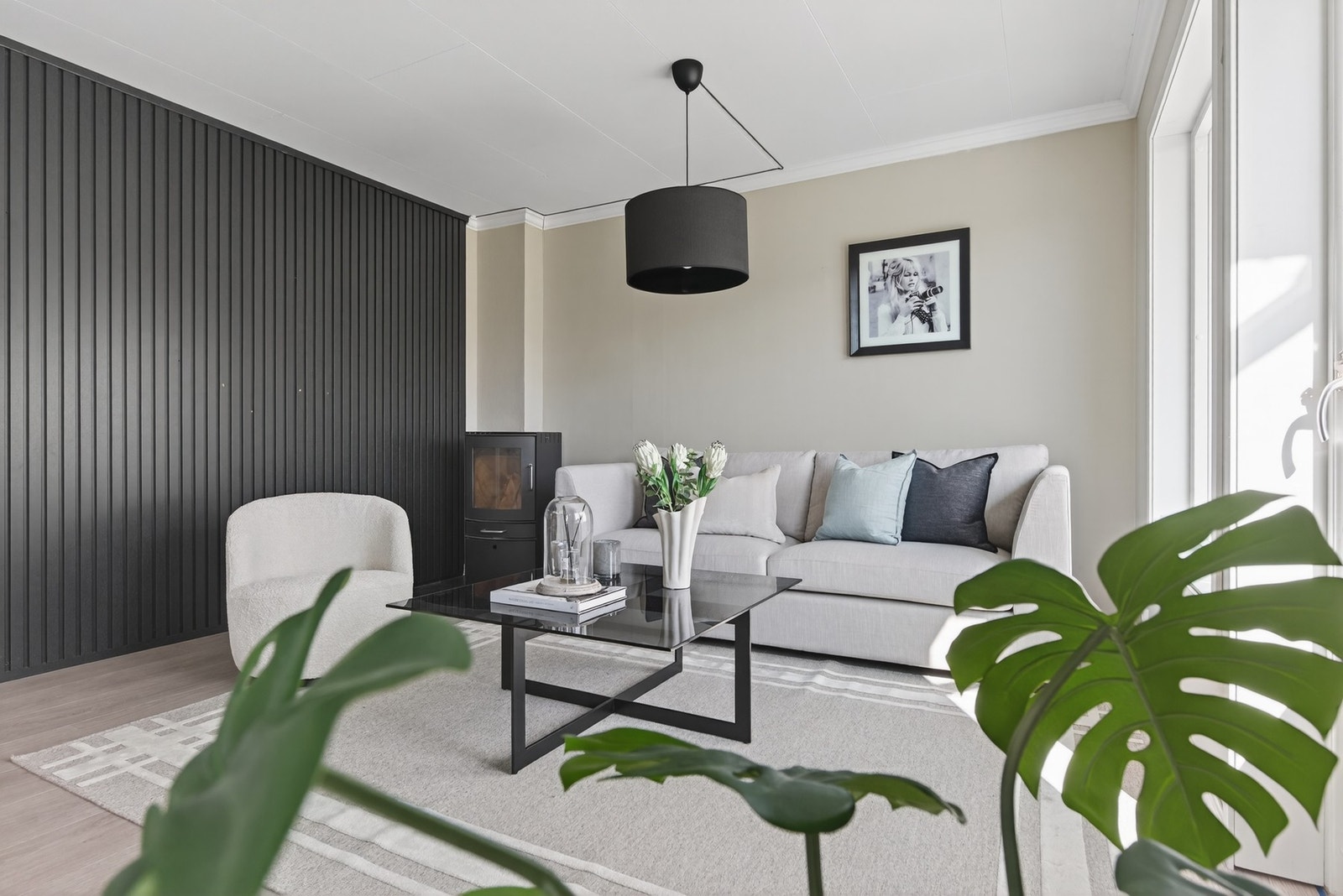 Den behagelige fargen i gulvet skaper en lun base som harmonerer med de lyse veggene, mens kontrastveggen i mørkere nyanse tilfører dybde og karakter til rommet Galleribilde