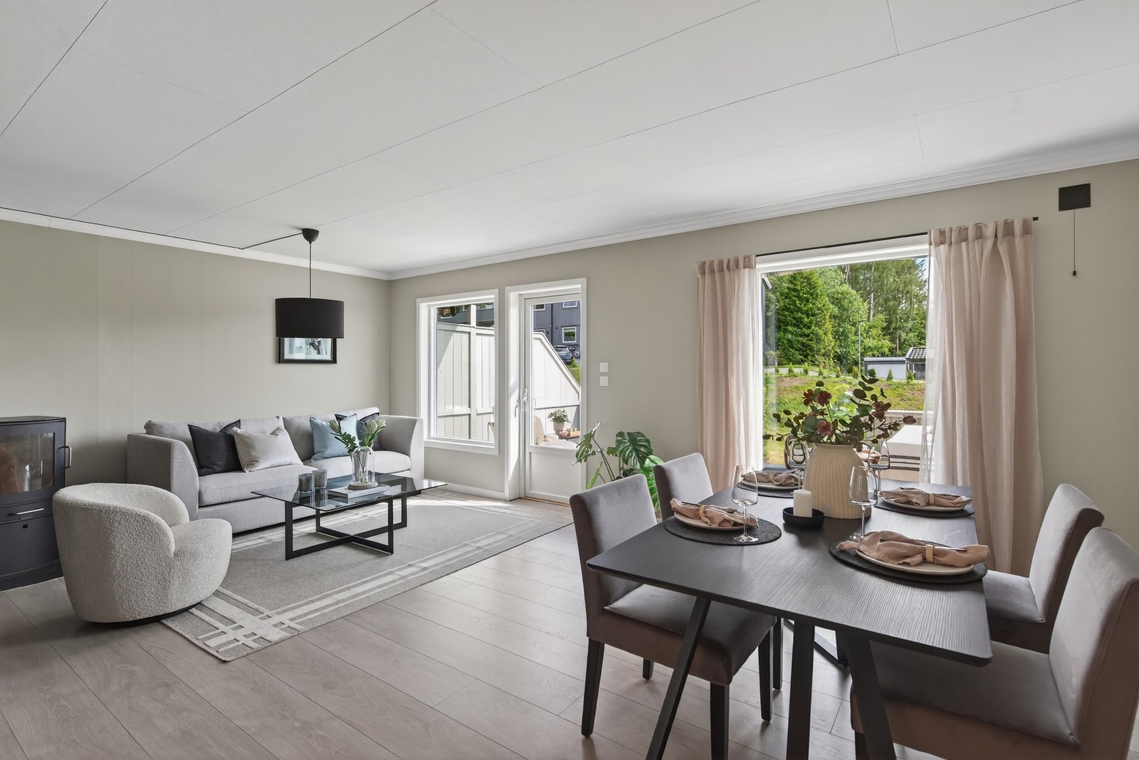 Her har du en stue med plass til både sofagruppe og spisestue - vedovnen gir rommet en lun og god varme Galleribilde