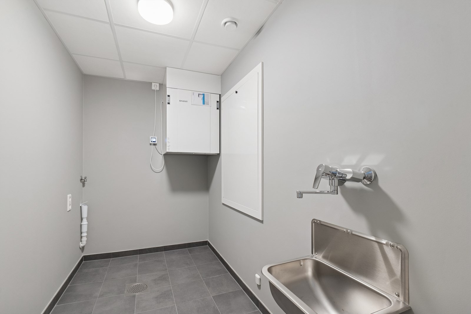 Praktisk vaskerom med opplegg for vaskemaskin og tørketrommel, samt utslagsvask. Galleribilde