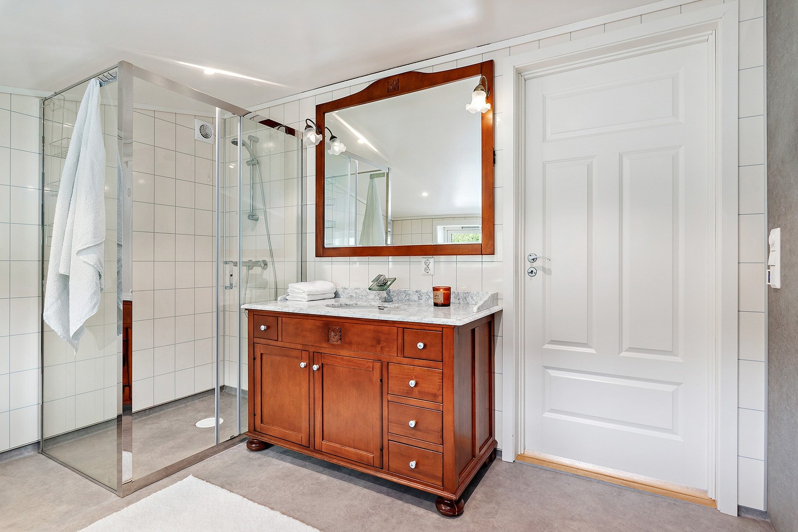 Badet i hovedetasjen har innredning med servantplate i helstøpt marmor og dusjhjørne med skyvedører. Galleribilde