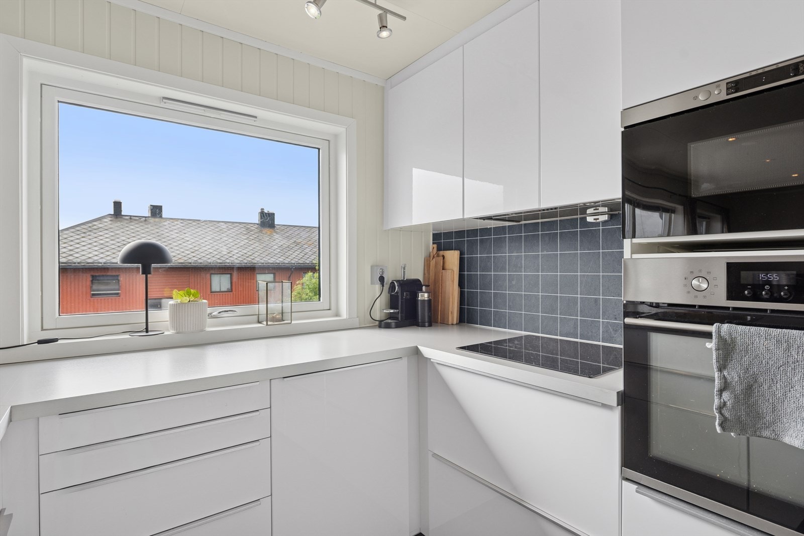 Kjøkkenet har en lys og moderne innredning - utstyrt med hvitevarer, inkludert kjøl/fryseskap, oppvaskmaskin, induksjonstopp, stekeovn og mikrobølgeovn. Galleribilde
