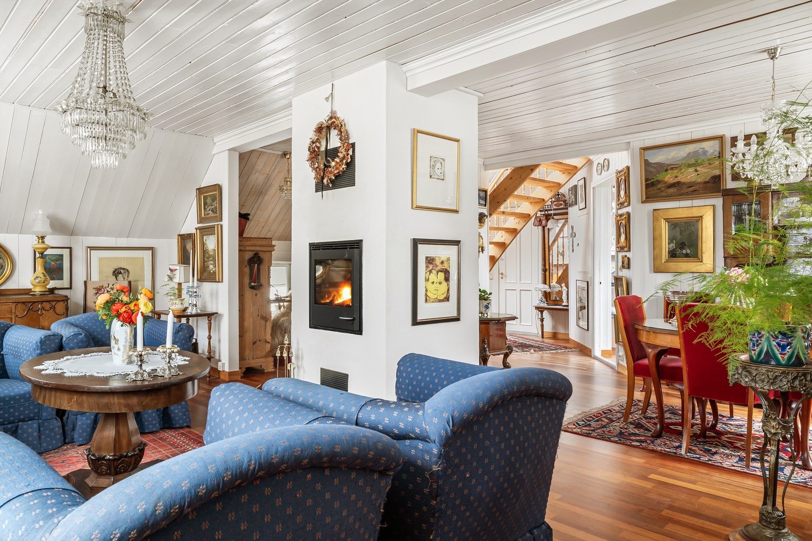 Stor stue med god plass til både sitte- og spisegruppe. Også her står peisovn strategisk plassert i rommet. Galleribilde