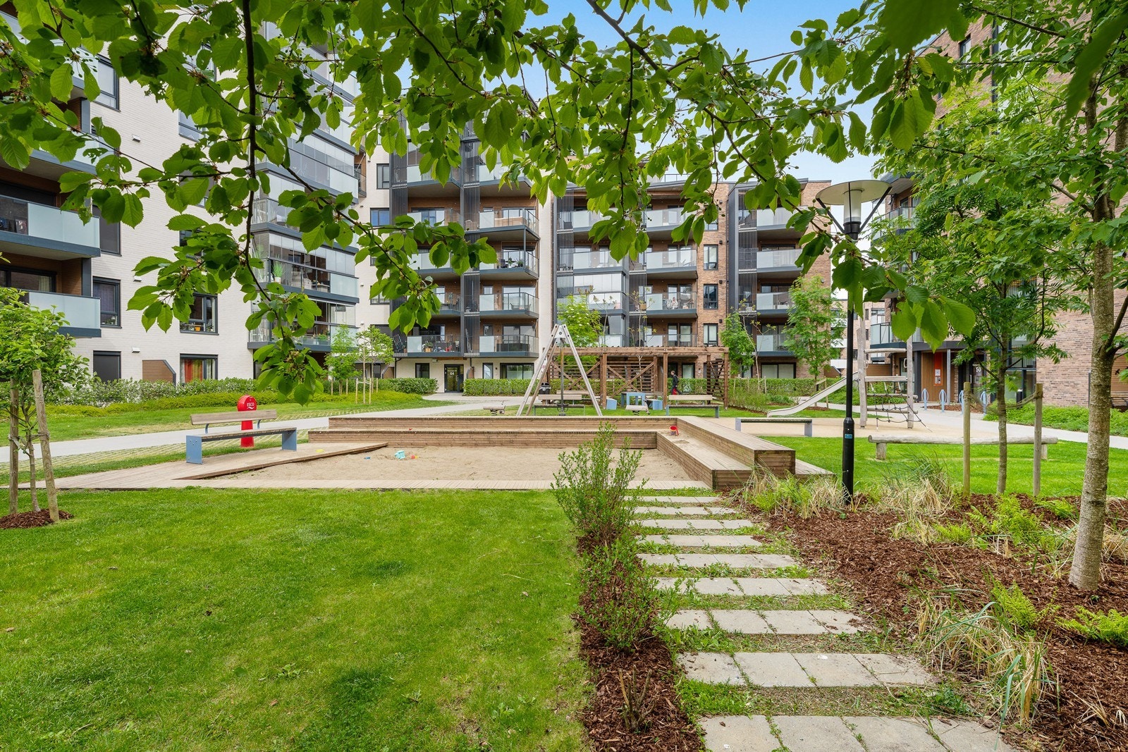 Velholdt hageområde med sittebenker og lekeplass. Galleribilde
