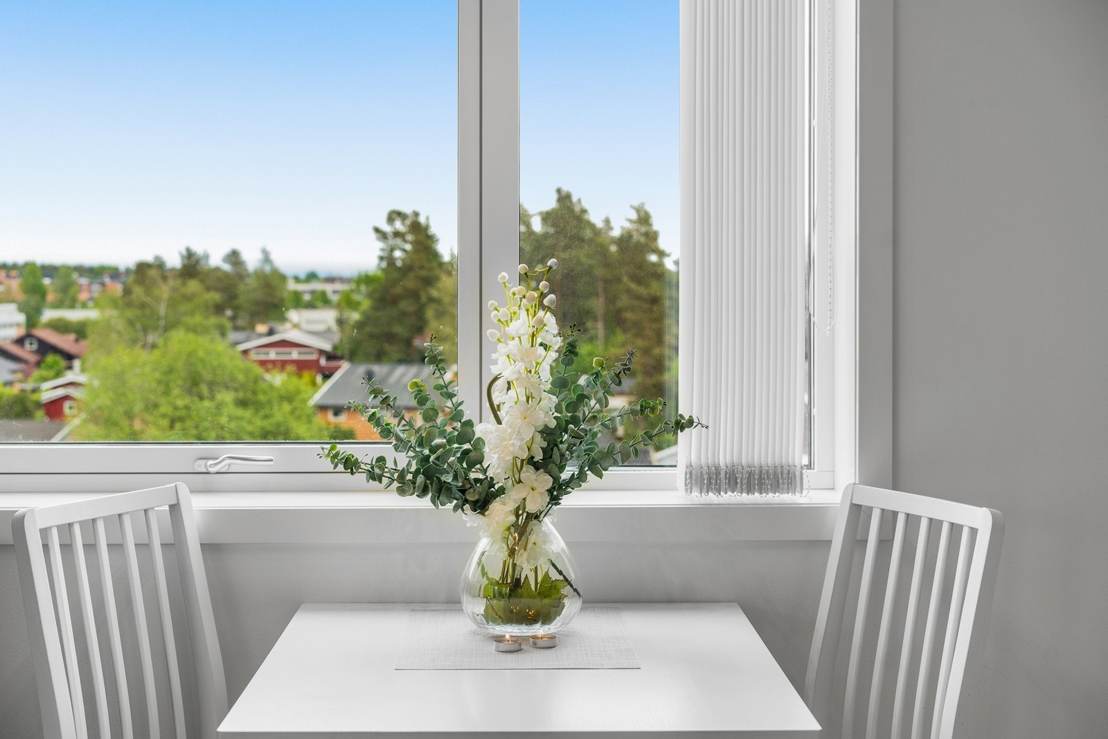 Sjarmerende spiseplass med dekorativ blomsteroppsats. Galleribilde