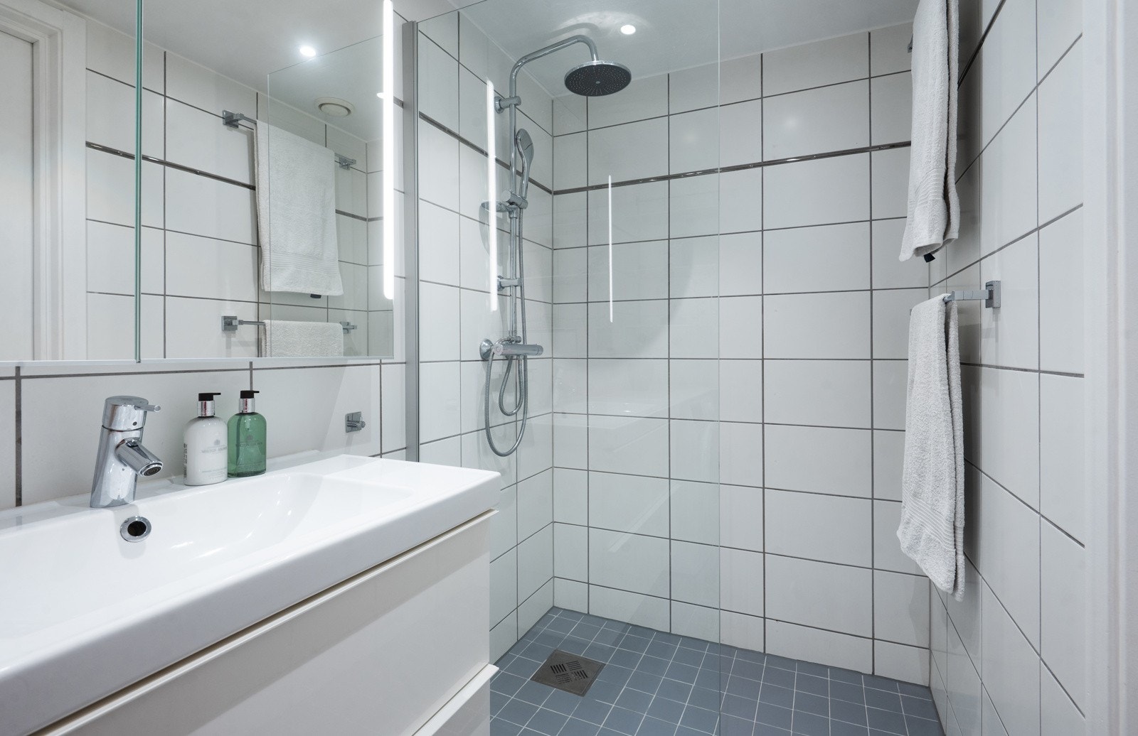 Innredningen består av speil, hvitt servantmøblement, høyglanset, turkis laminatbenkeplate, og toppmontert servant Galleribilde