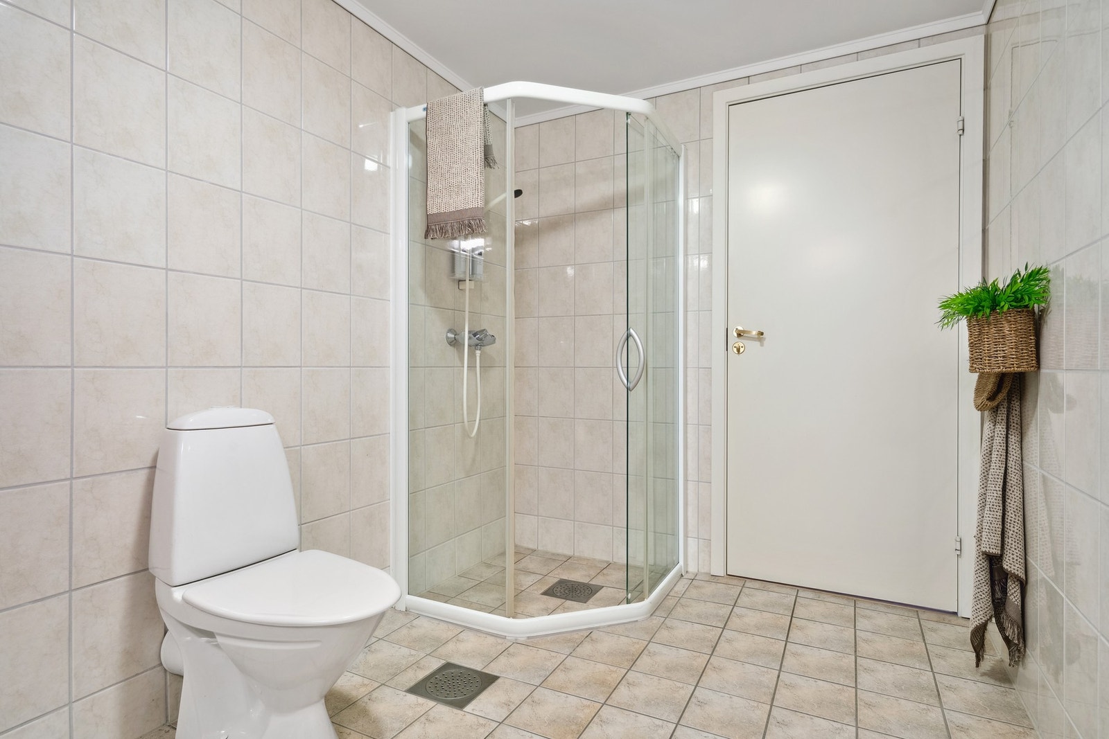 Badet er utstyrt med servantinnredning, speil med overlys, toalett og dusjhjørne. Galleribilde