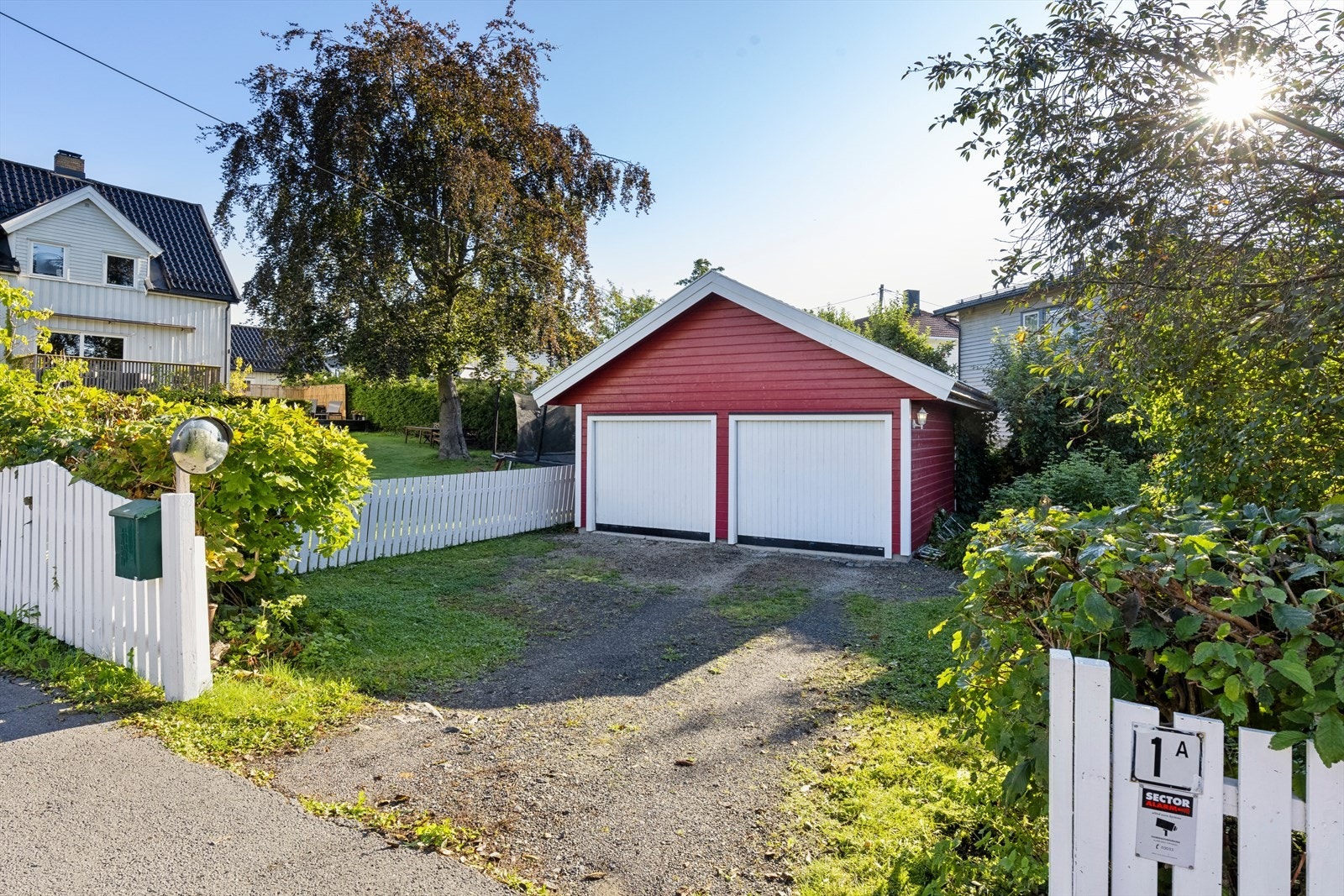 Stor, romslig dobbelgarasje med flere oppstillingsplasser og en pent opparbeidet passasje ned til huset. Velkommen til visning! Galleribilde