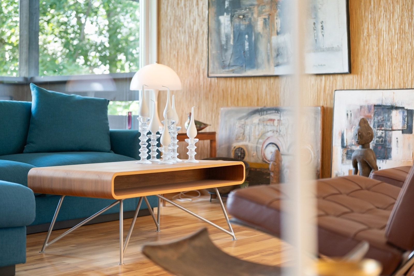 Stue med moderne møbler og kunst på veggene, store vinduer som slipper inn naturlig lys. Galleribilde