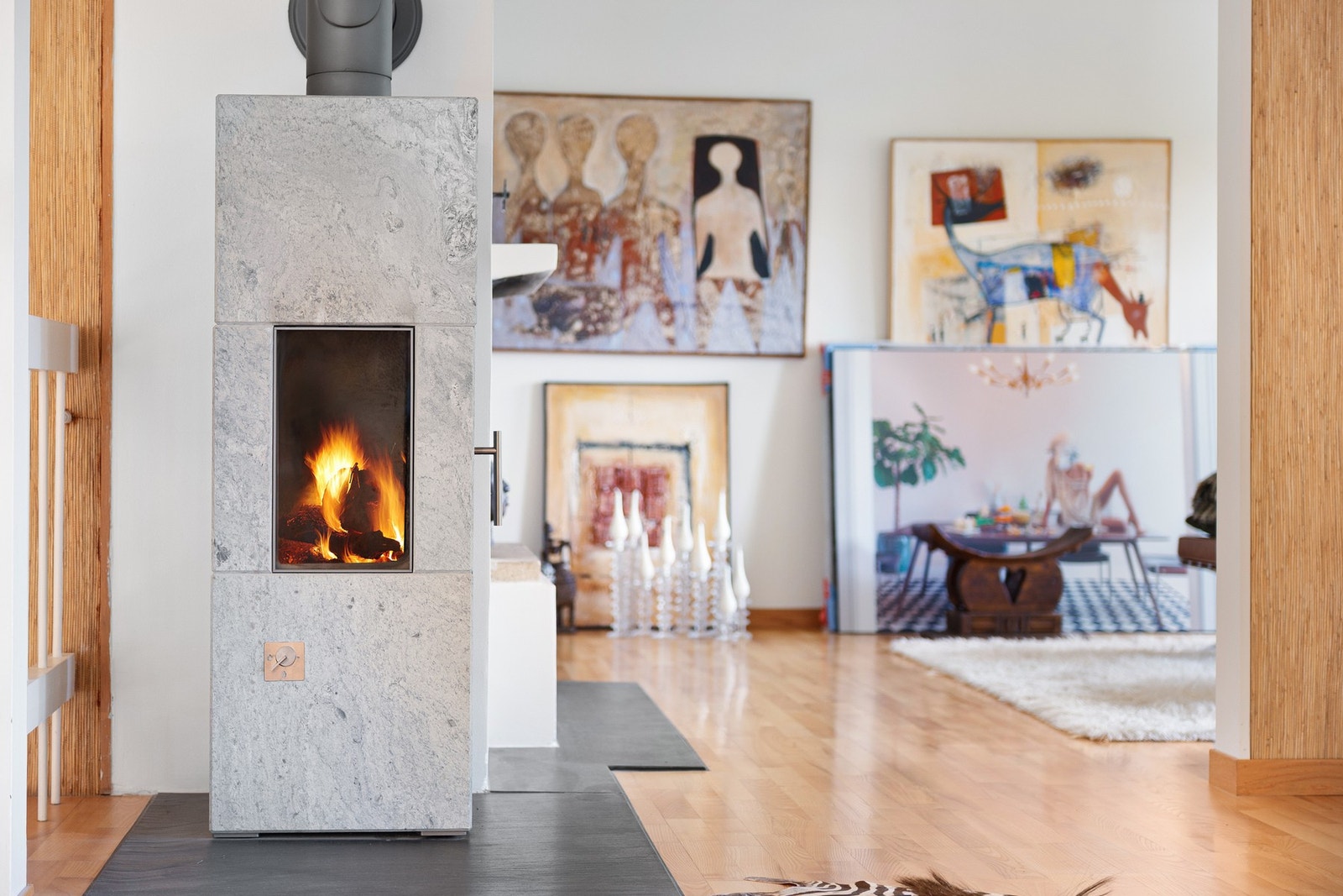 Peis i stein med levende flammer, treverk på gulv og kunst på veggene. Rais kleberstenpeis innstallert, (Fyr og Flamme) Galleribilde