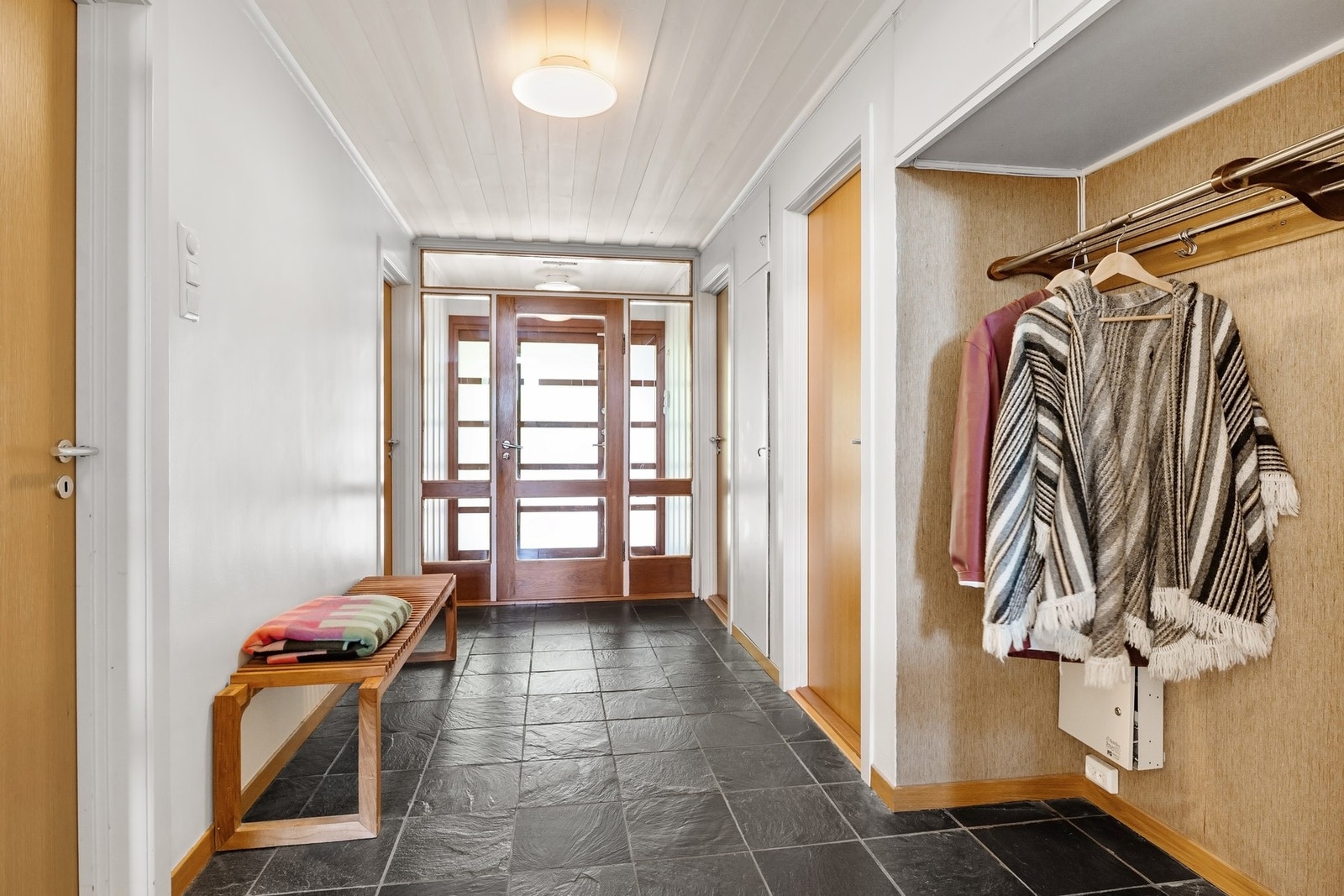 Lys og romslig entré med flislagt gulv og god plass til oppbevaring. Alle innvendige dører byttet i finert eik. (Østby trevare/Bygg-It) Galleribilde