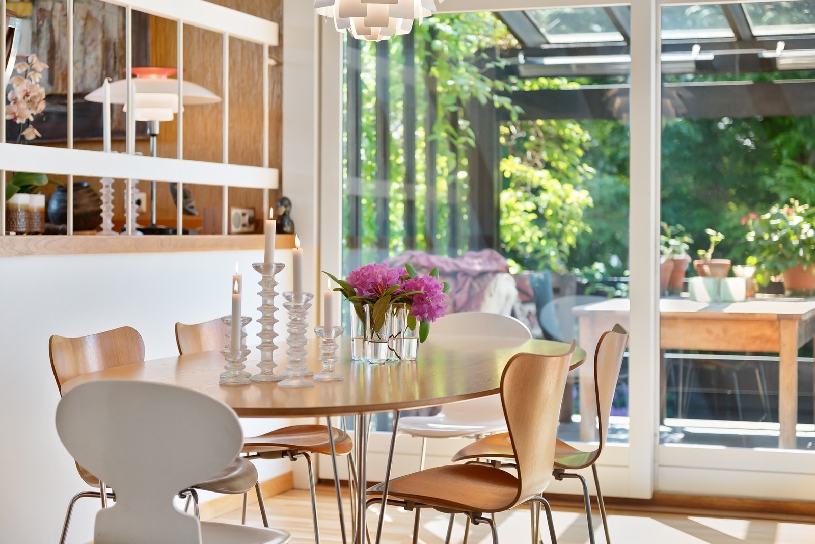 Spisestue med store vinduer med utsikt til hage og flott uteområde ved bassenget. Galleribilde