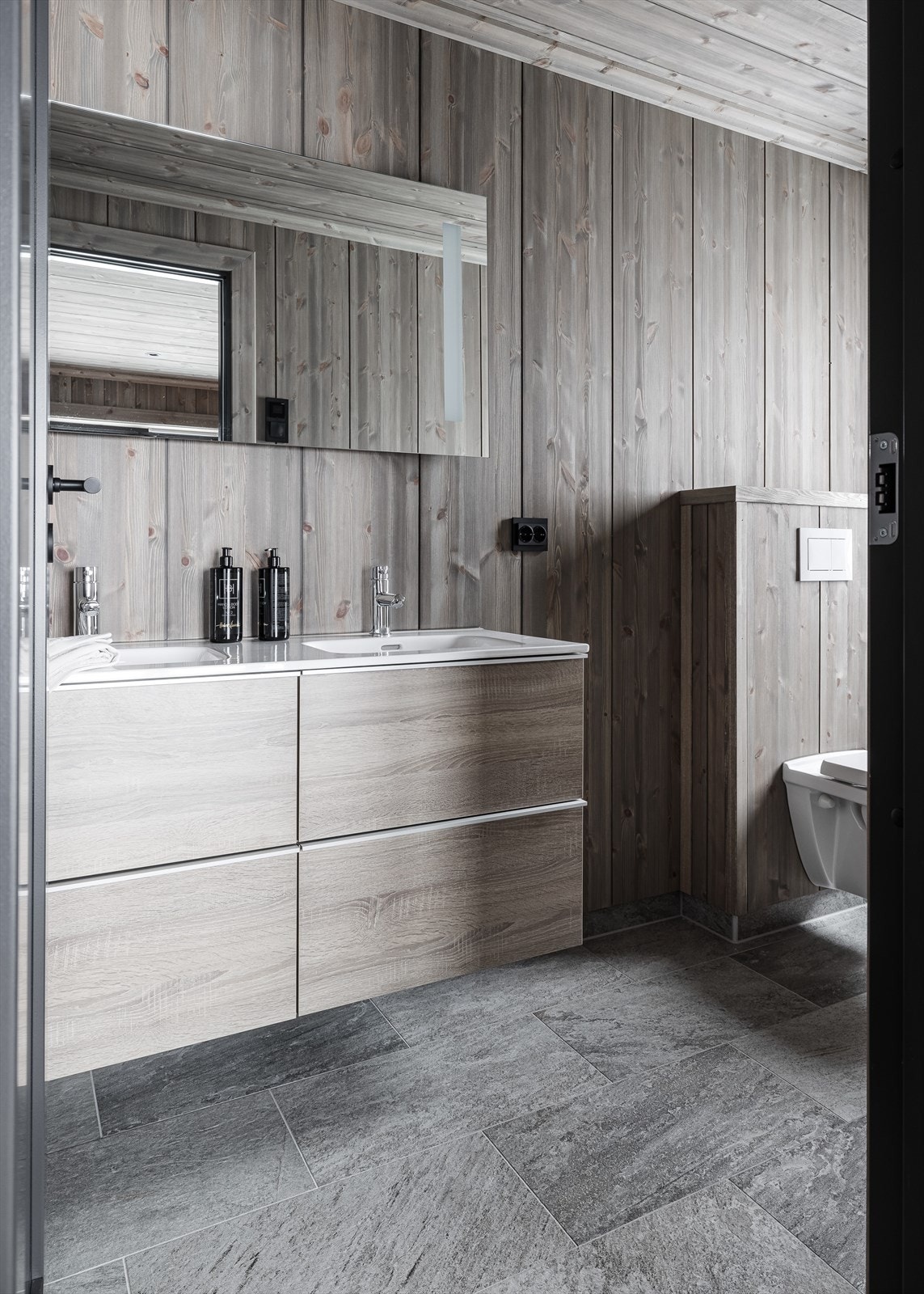 Badet her har også smakfulle fliser, varmekabler i gulv og stor dusjnisje Galleribilde