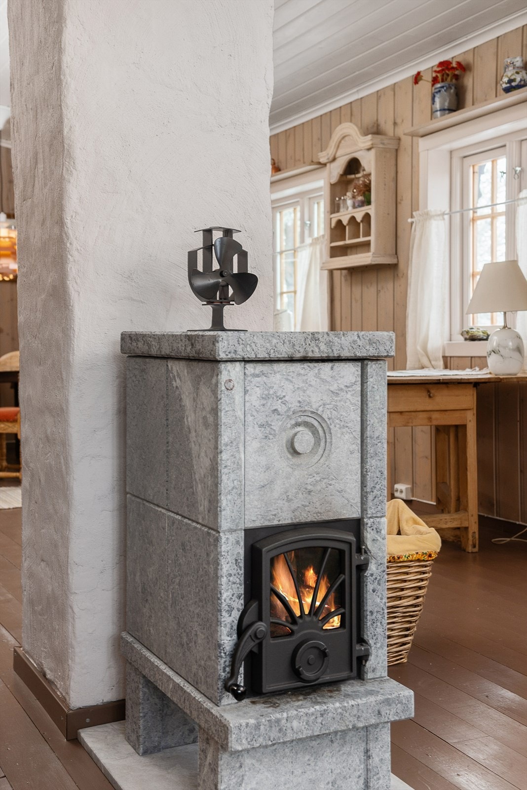 Klebersteinsovn som magasinerer varme godt er montert mot midten av rommet Galleribilde