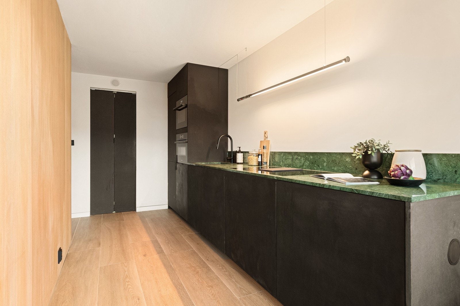 Alle hvitevarene er integrert; induksjonstopp, stekeovn, oppvaskmaskin, mikrobølgeovn og en kombinert kjøl/frys. Galleribilde