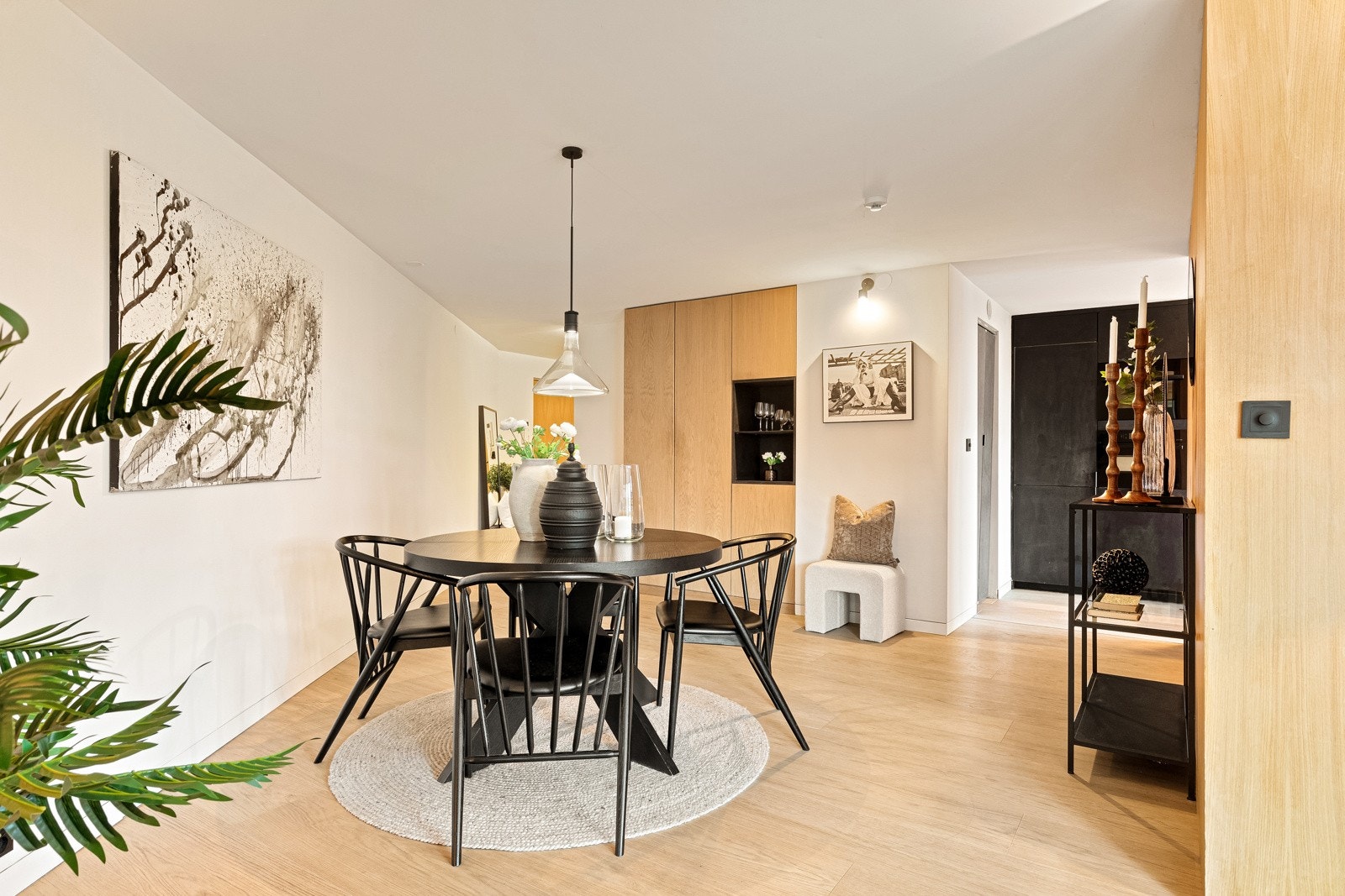 Utenfor kjøkkenet har stuen en egen spisesone med rundt bord. Galleribilde