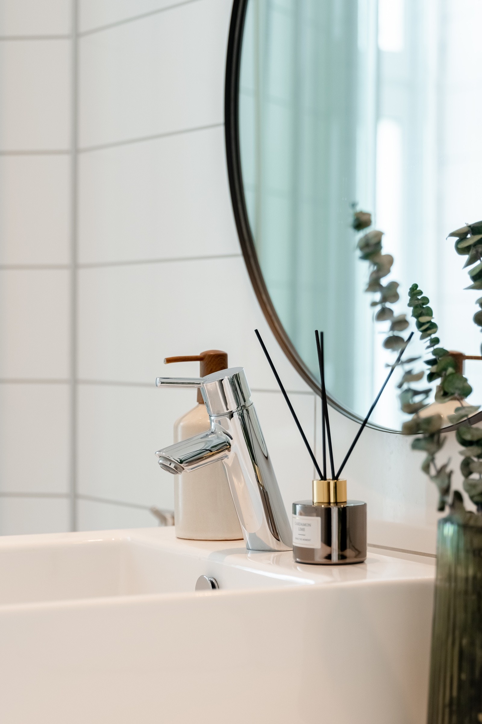 Rommet er innredet med vegghengt servantskap med skuffer, benkeplate av laminat med ovenpåliggende servant med ett-greps armatur, og speil på vegg over servant. Galleribilde