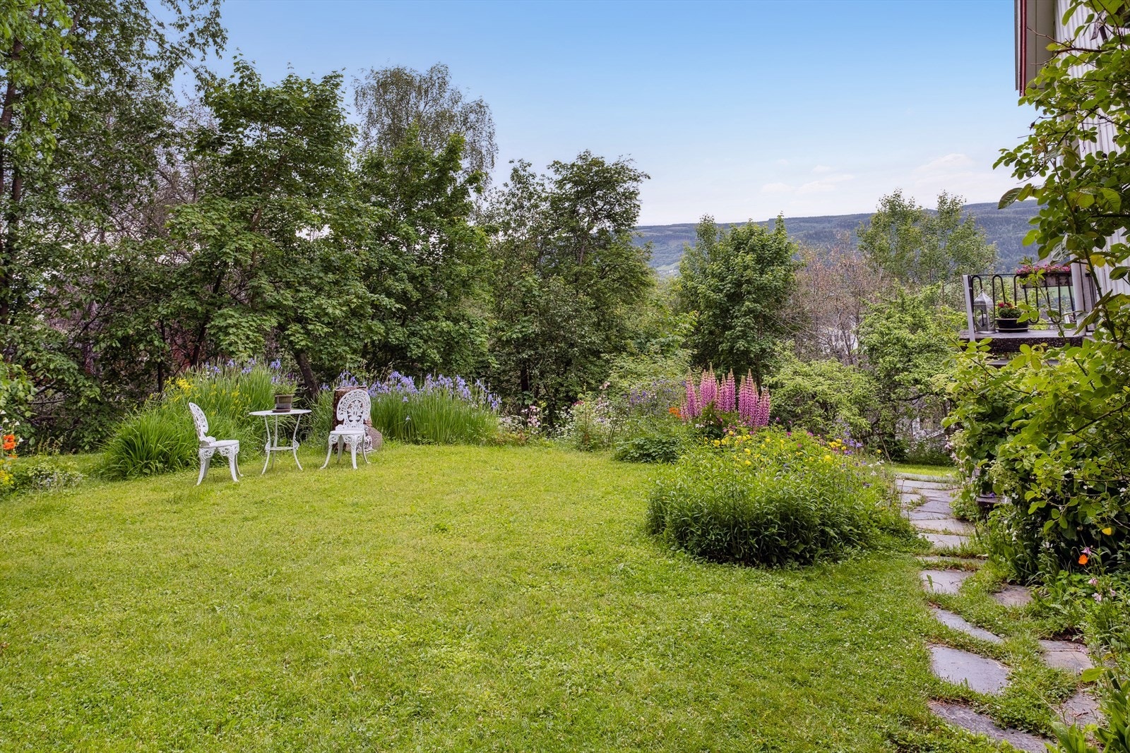 Tomten er opparbeidet med plen og beplantning. Galleribilde