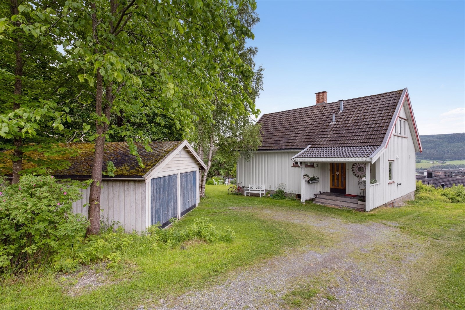 Eiendommen har gruset adkomstvei og gårdsplass, med tilgang til parkering i dobbel garasje. Galleribilde