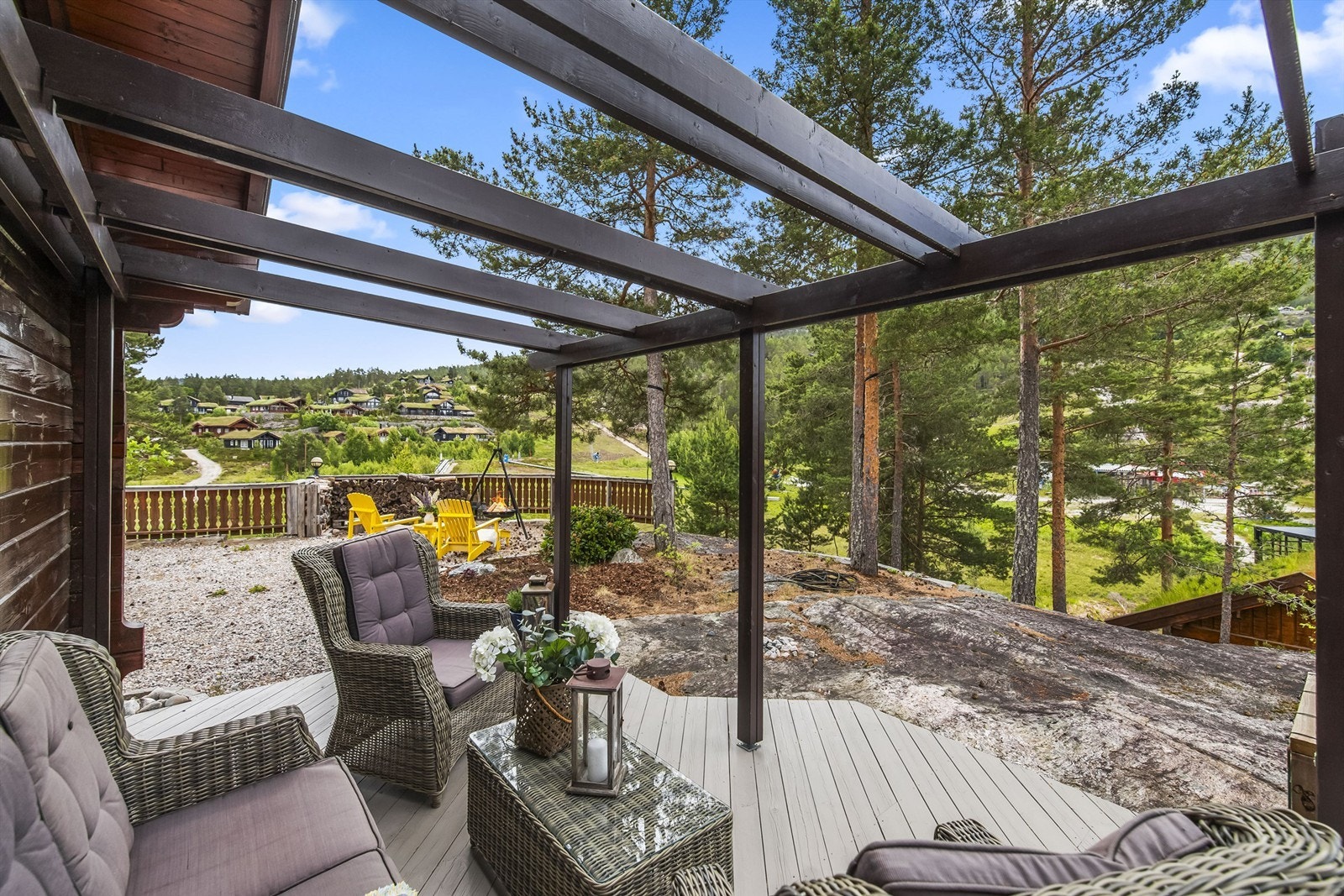 Fra stuen har man utgang til terrasseområdene. Tomten er en naturtomt, med fjell, busker og trær. Idyllisk og usjenert. Galleribilde