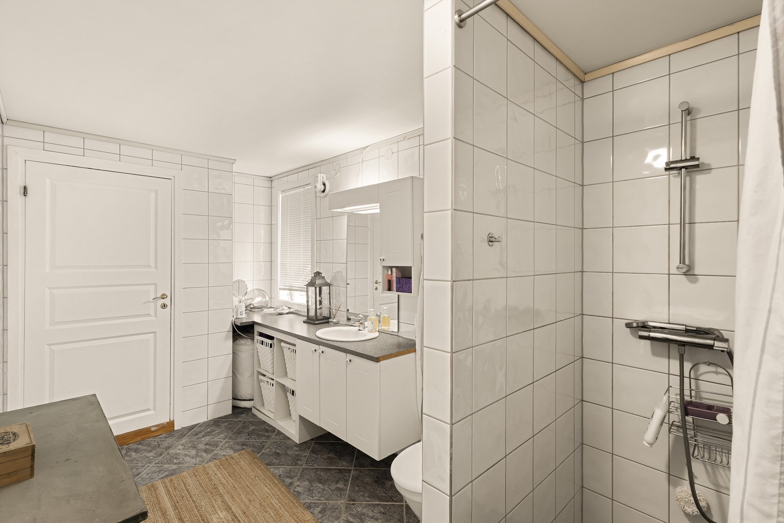 Badet er innredet med toalett, dusjnisje, opplegg for vaskemaskin og servant med innredning/speil/belysning. Galleribilde