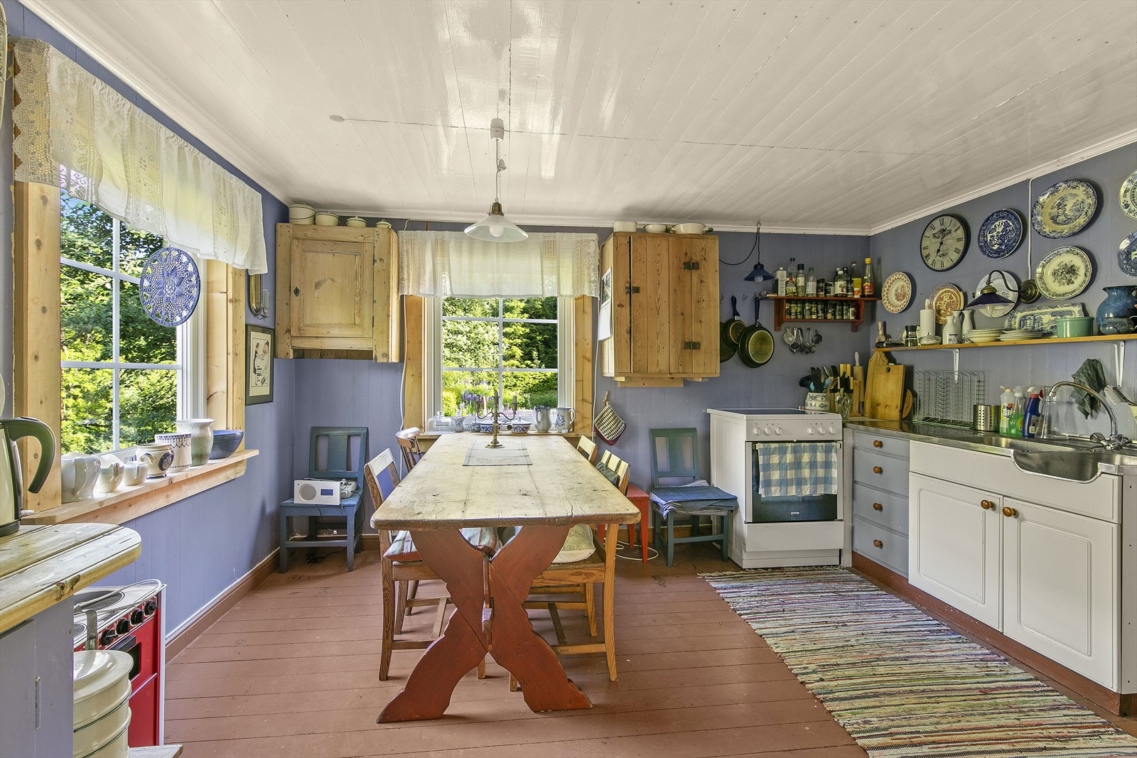 Kjøkkenet inneholder profilerte fronter, frittstående hvitevarer og benkeplate i tre. Galleribilde