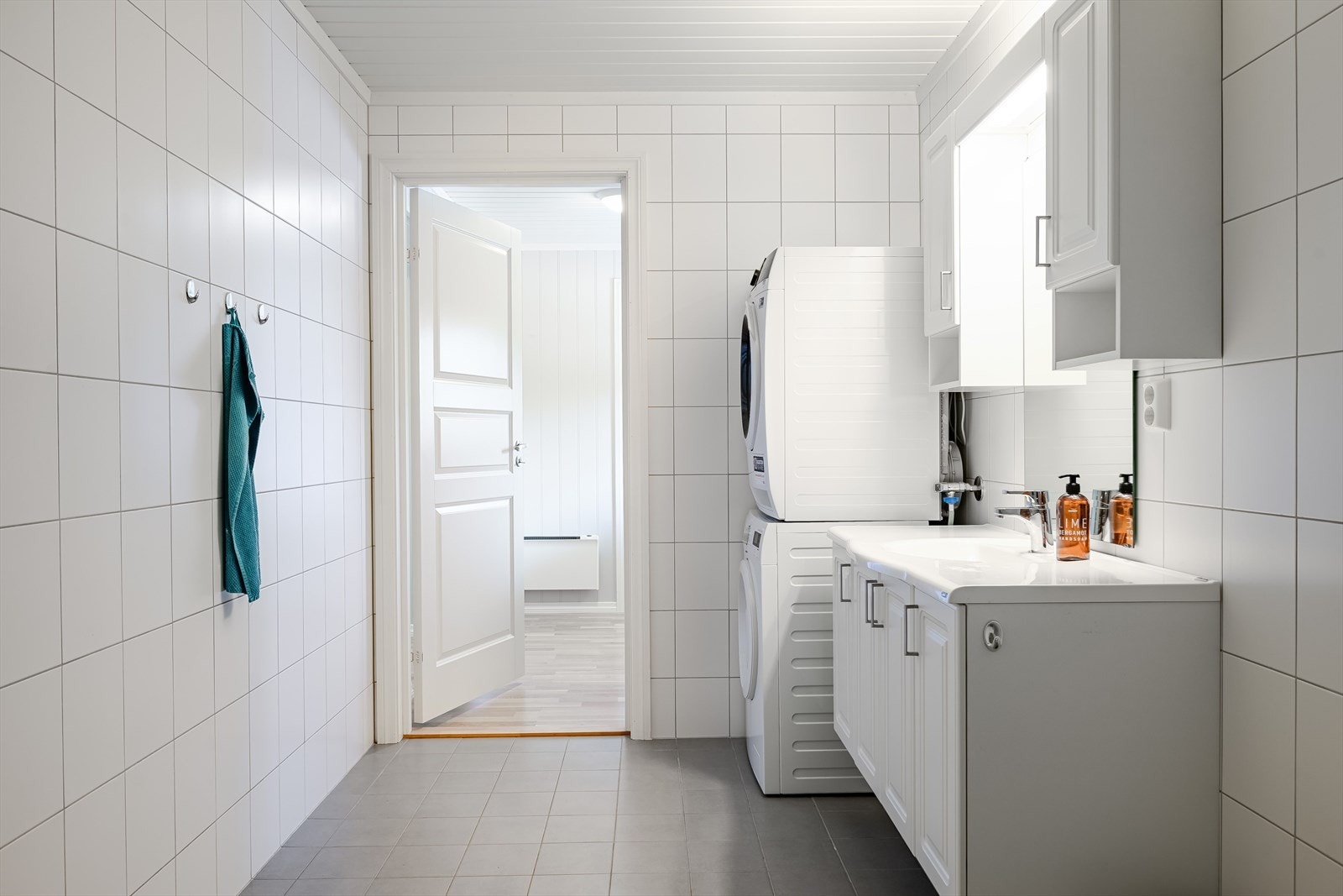 Baderommet har grå fliser på gulv med gulvvarme, hvite fliser på veggene og mekanisk avtrekk tilknyttet balansert ventilasjon. Galleribilde