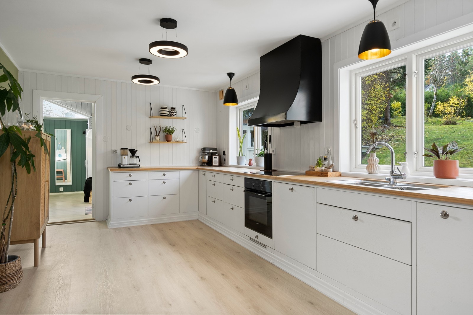 Fin utsikt til tomten gjennom vinduene som vender mot vest. Rommet du ser inn til venstre i bildet er et stort soverom. Galleribilde