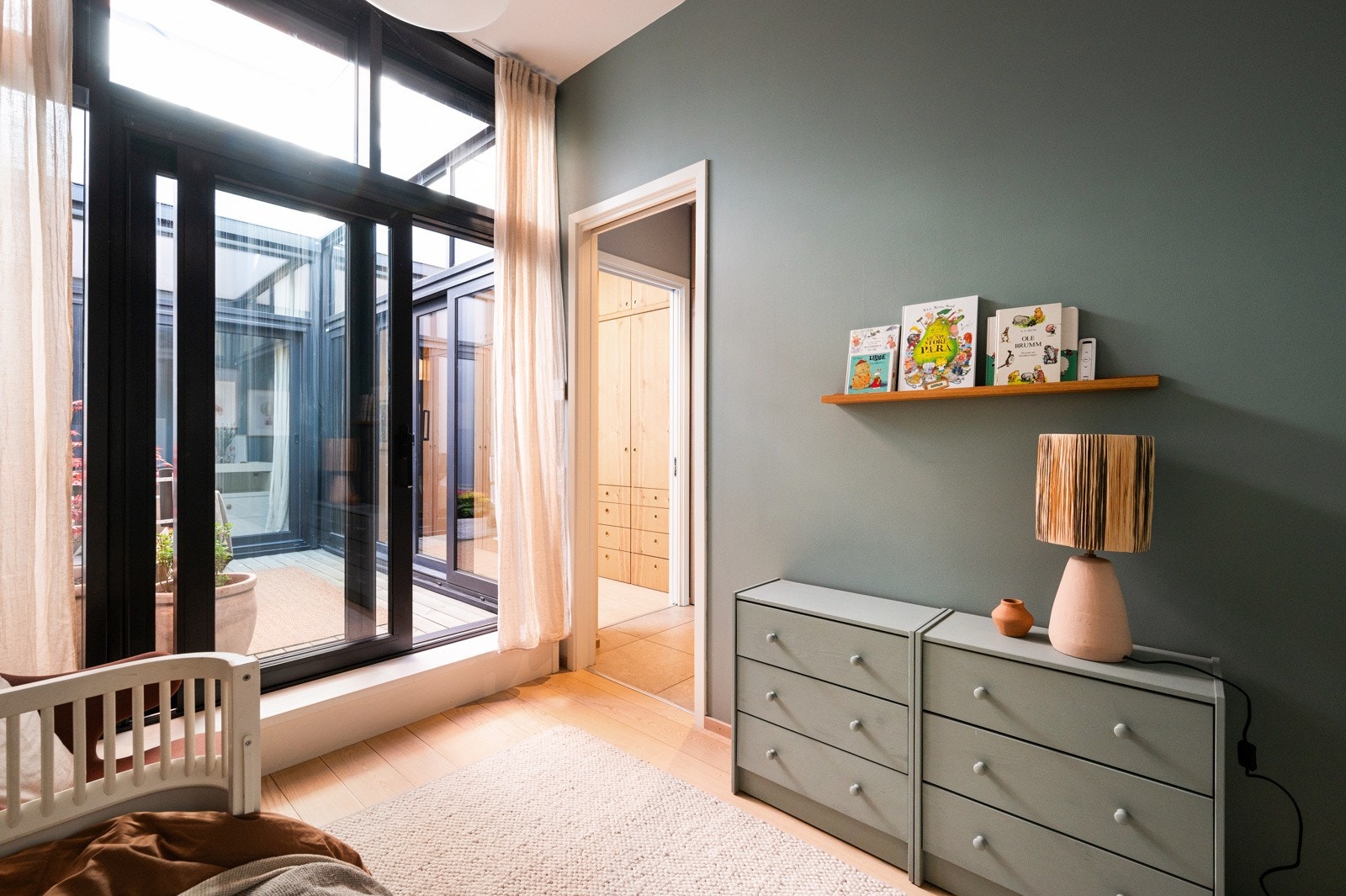 Leilighetens første etasje inneholder to stilfulle og innbydende soverom, begge med direkte adkomst til et lyst og luftig atrium på 8,7 m². Galleribilde