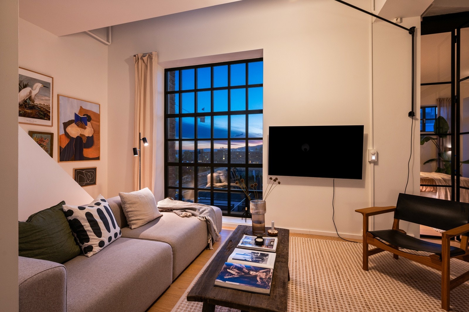 De sorte vindusrammene og rekkverket på trappen fremhever den moderne stilen og gir stuen et eksklusivt uttrykk. Galleribilde