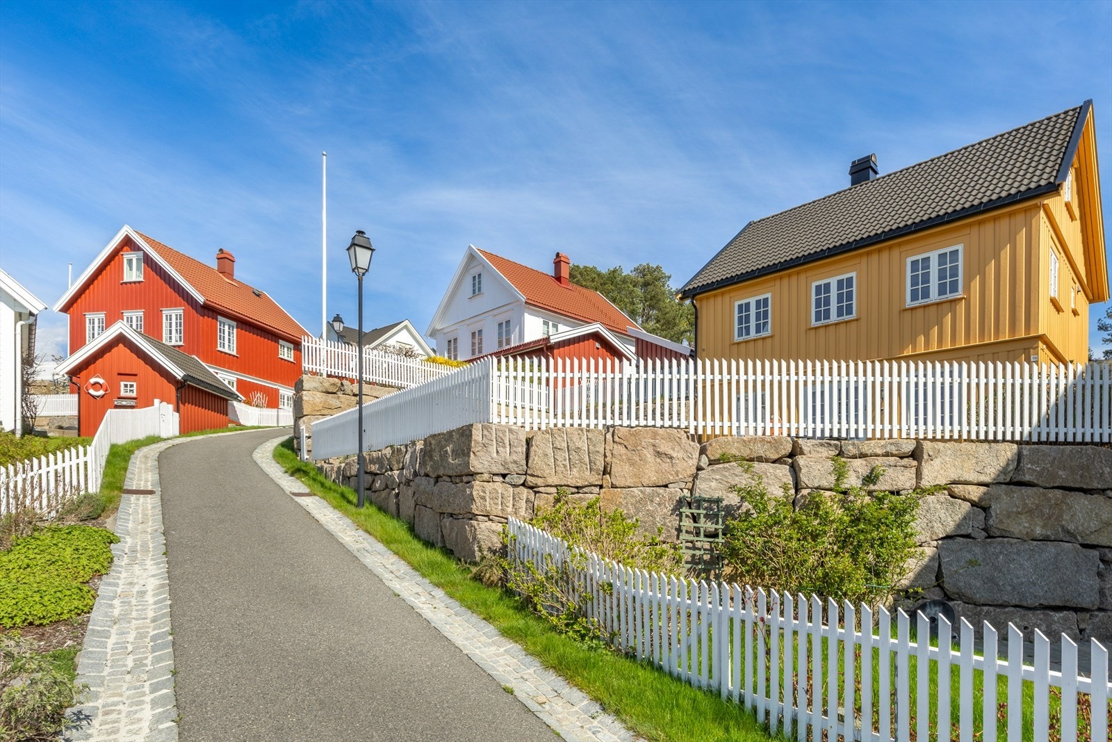 Asfalterte adkomstveier og brosteinsbelagte gangveier fører deg til hytta Galleribilde