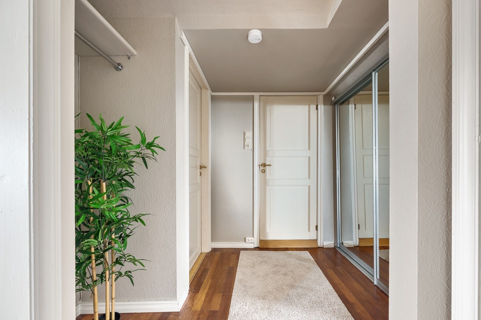 Nymalt og lys gang med praktisk skyvedørsgarderobe som gir god oppbevaringsplass. Galleribilde