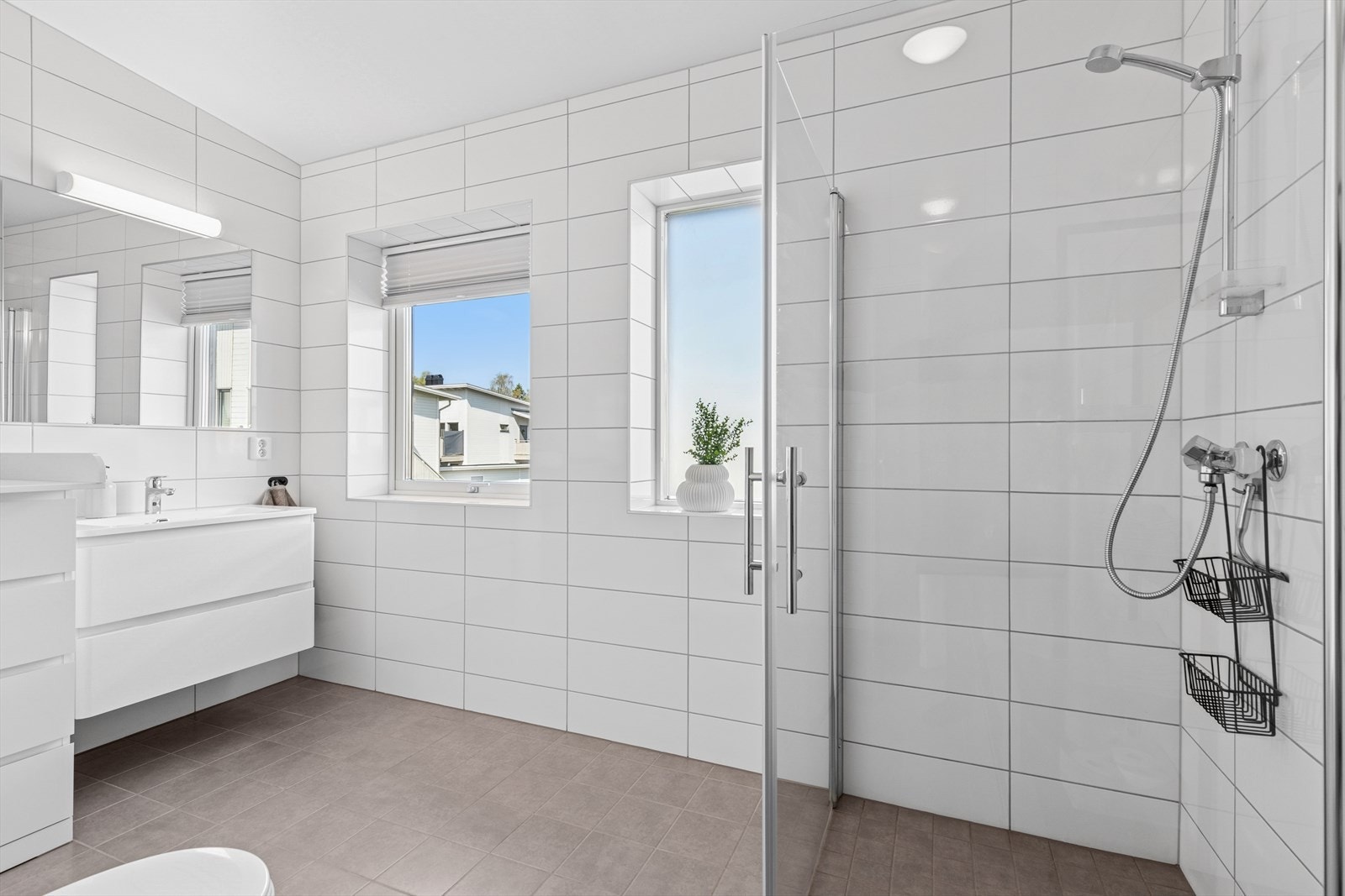 Dusjen er plassert i nedsenket nisje i hjørnet og har dører av glass. Galleribilde