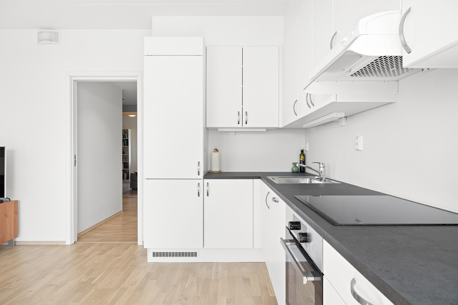 Kjøkkenet gir et lyst og luftig inntrykk, med god skap- og benkeplass som gjør matlagingen praktisk. Galleribilde