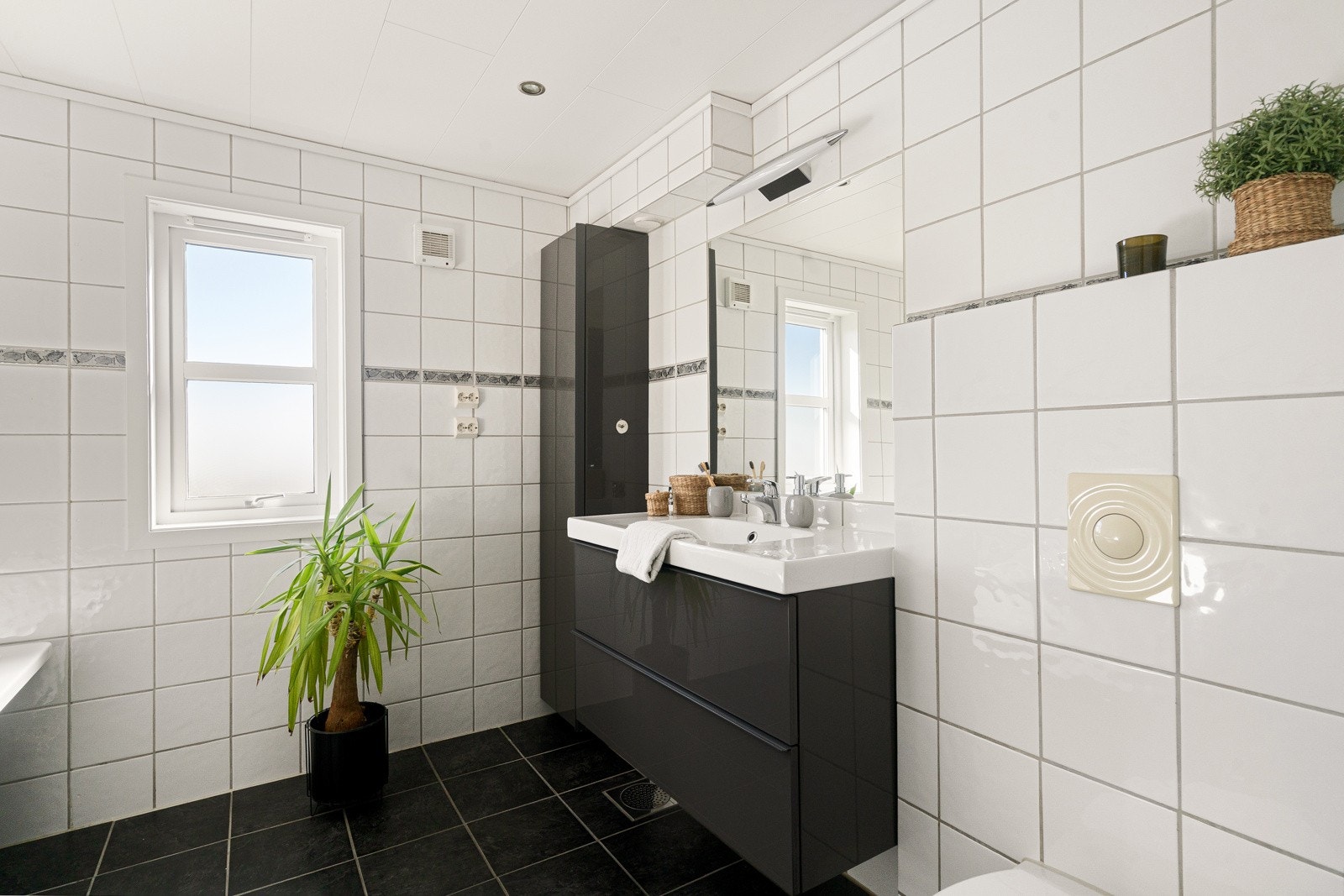 Helflsiet bad med vegghengt toalett og badekar. Moderne baderomsinnredning med god skap- og skuffeplass Galleribilde