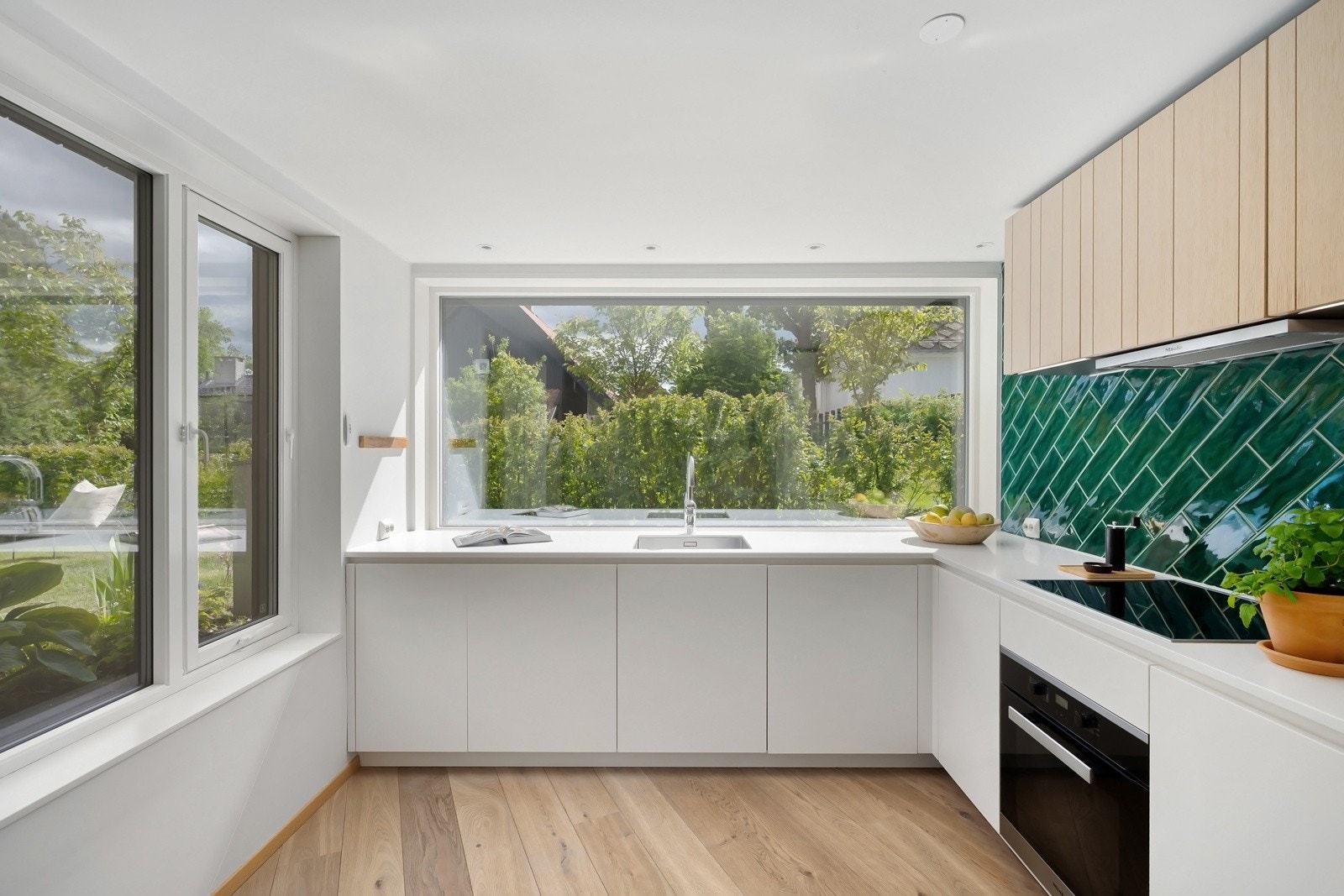 Eksklusivt kjøkken fra Poliform Varenna med integrerte hvitevarer og store vindusflater. Galleribilde