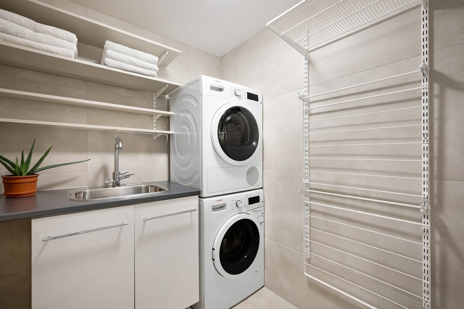 Vaskerom med opplegg for vaskesøyle og utslagsvask - Praktisk tørkestativ på vegg. Galleribilde