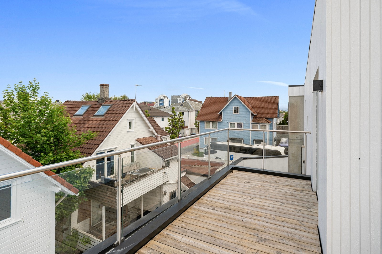 Balkongen har dekke av terrassebord og rekkverk i glass. Galleribilde