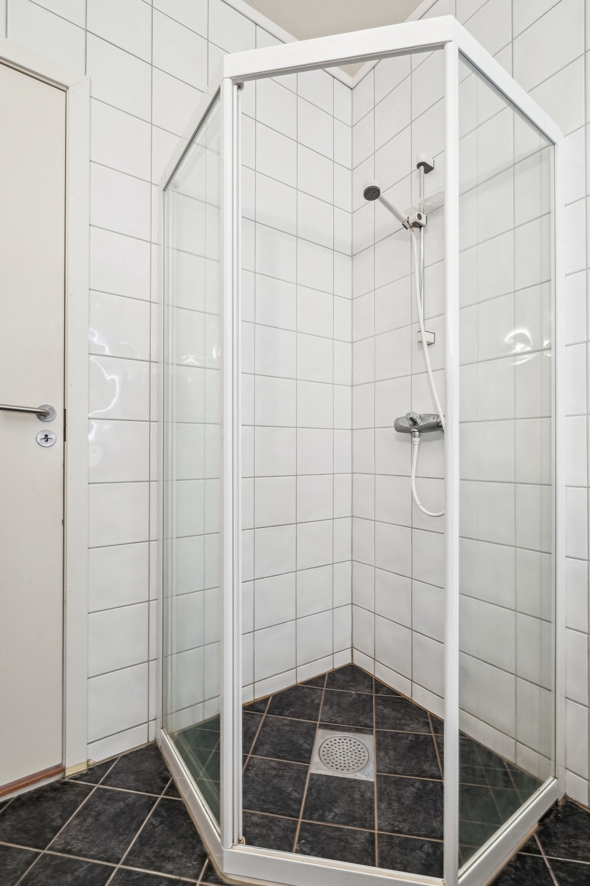 Badet er ustyrt med toalett og dusjhjørne med skyvedør med glass. Opplegg for vaskemaskin. Galleribilde