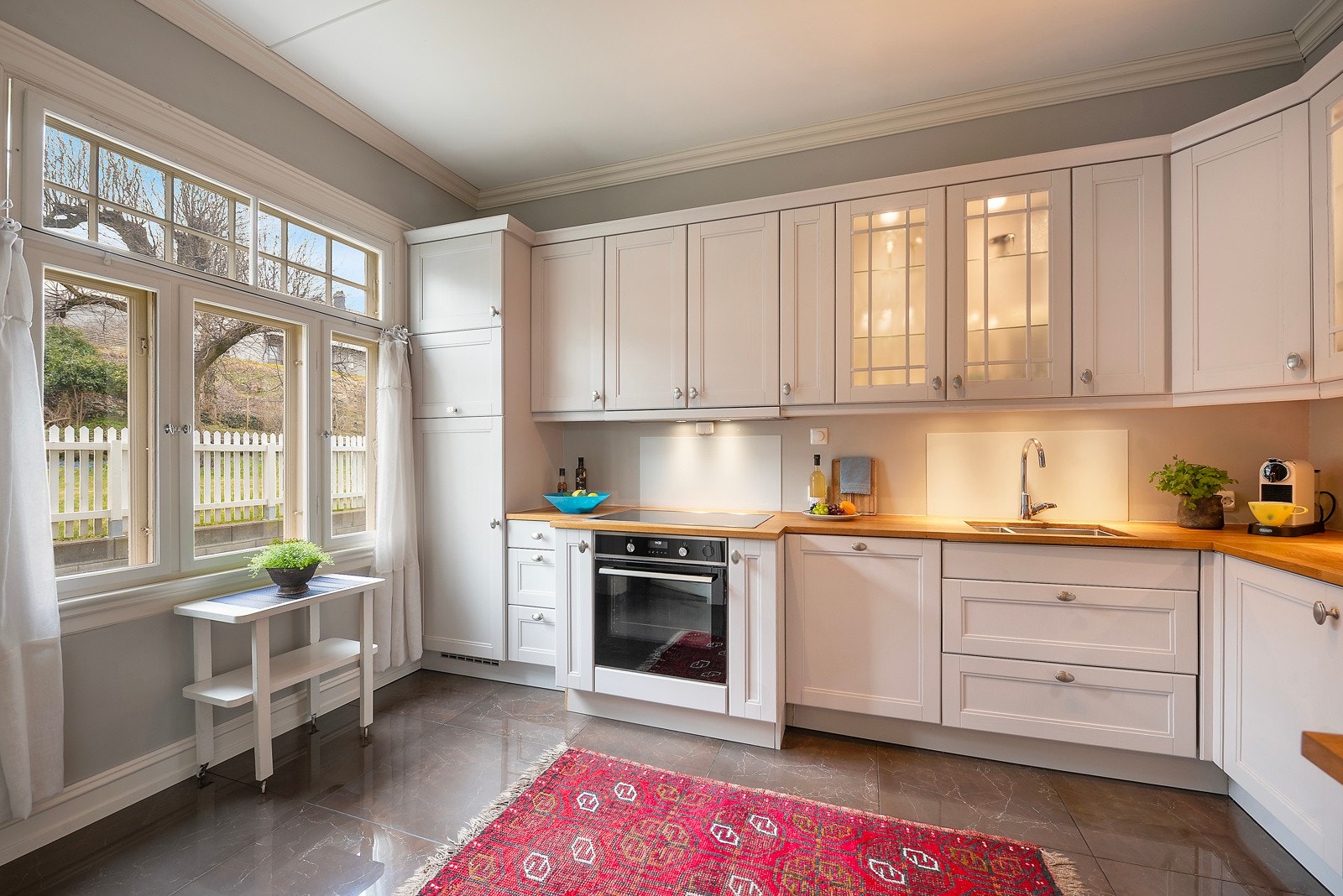 Videre inn ligger et klassisk kjøkken fra 2017. Det er kjøleskap, oppvaskmaskin, platetopp og stekeovn, Galleribilde