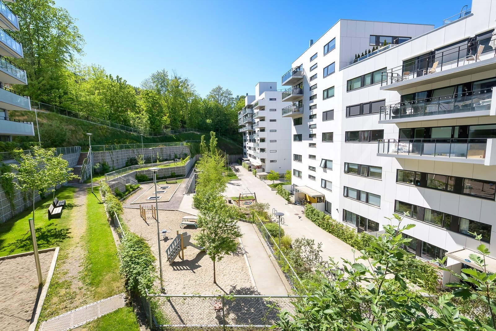 Pent opparbeidet bakgård med lekeplass og grøntarealer for beboerne Galleribilde