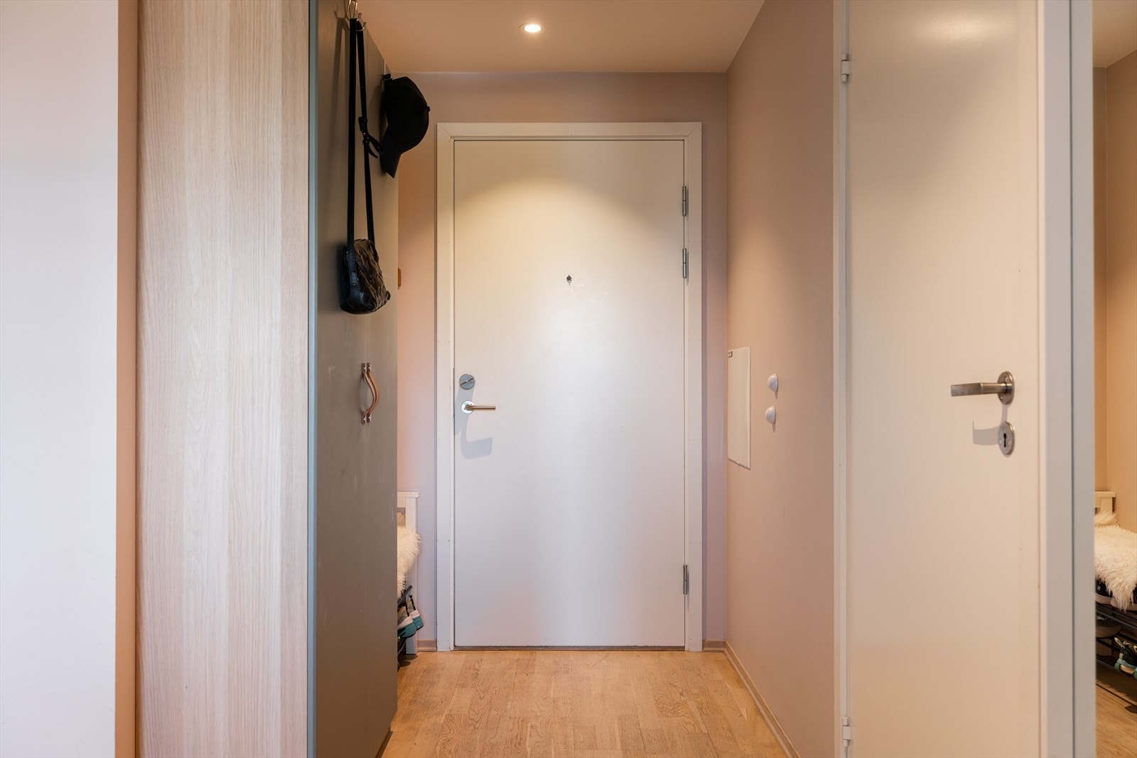 Lys og innbydende entré med god plass til å henge fra seg yttertøy og sko i garderobeskap Galleribilde