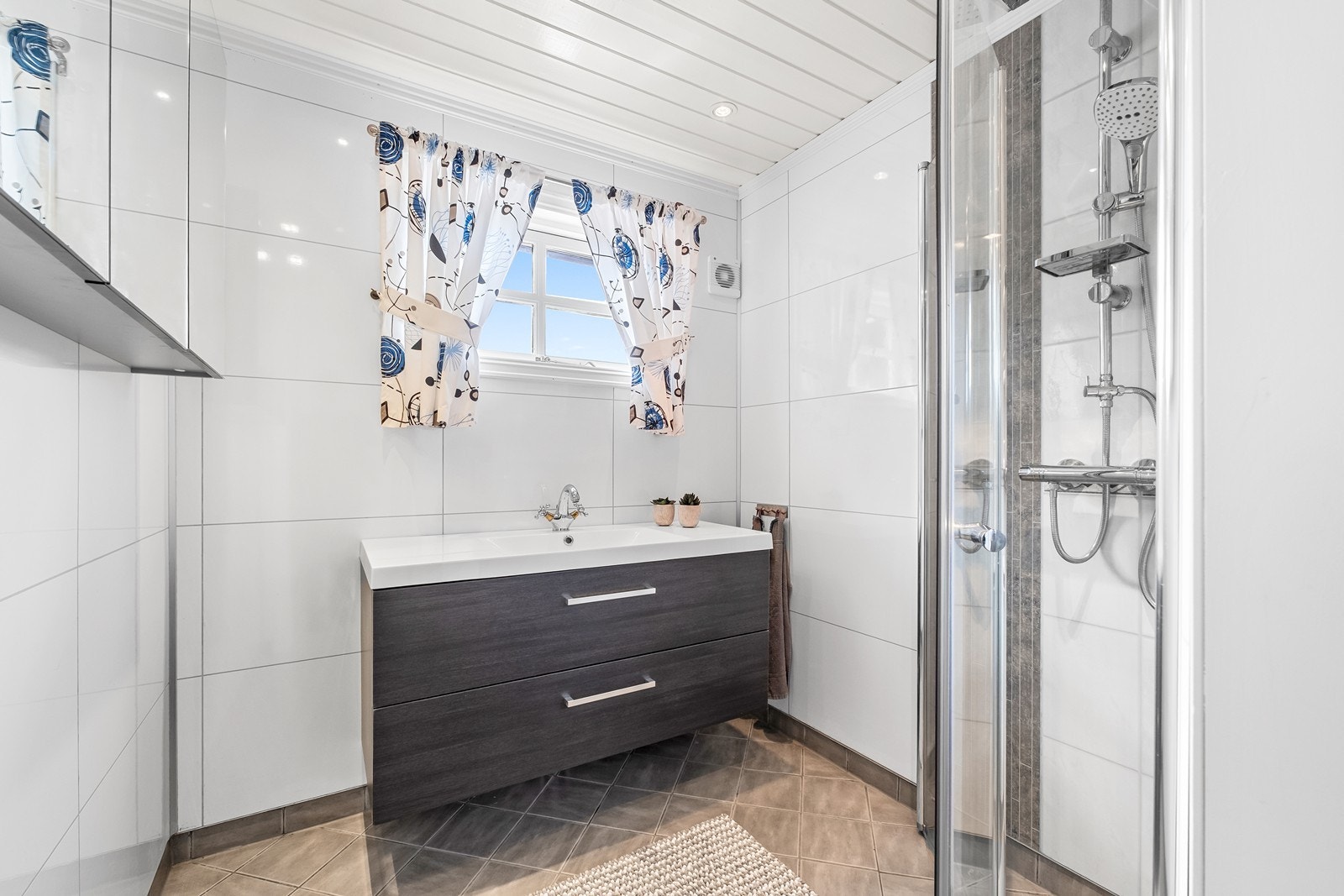 Bad med dusjhjørne og helstøpt servant med underskap. Galleribilde