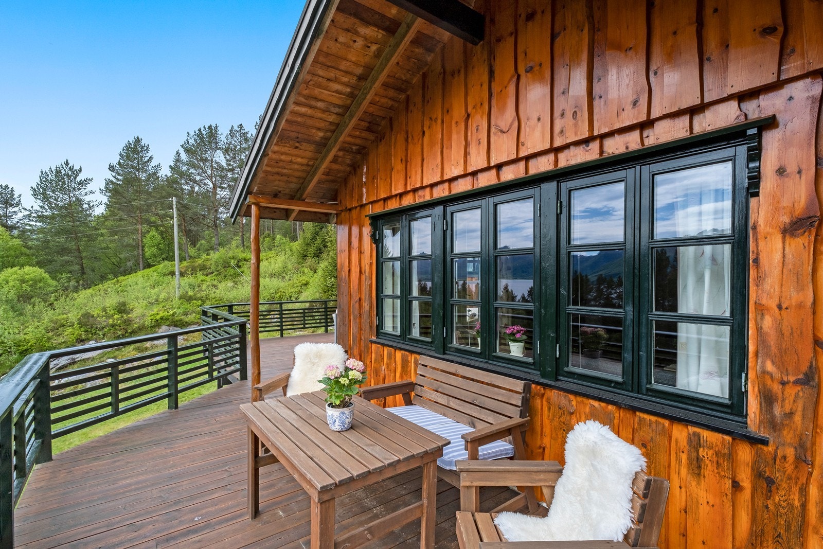 Terrassen strekker seg rundt hytta, og her kan man nyte morgenkaffen på solrike sommerdager. Galleribilde