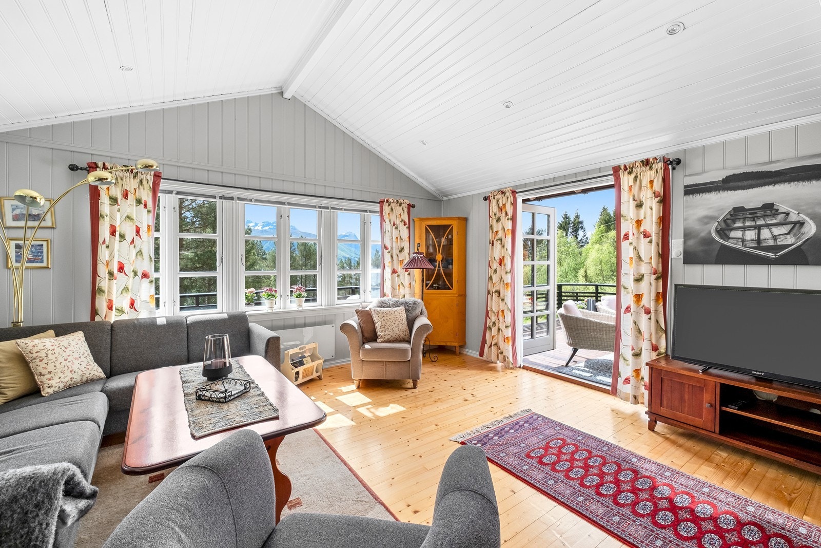 Store vinduer og doble terrassedører lar uteplassen komme inn. Galleribilde