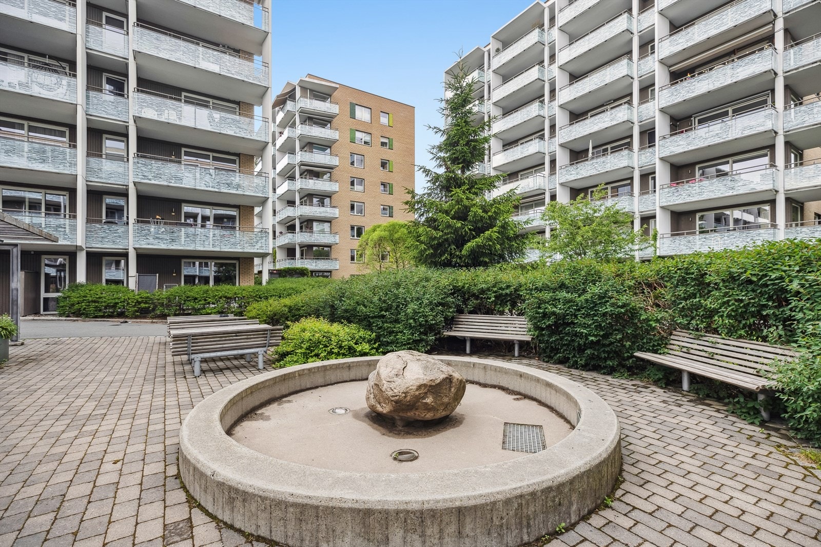 Hyggelig bakgård med beplantning og benker. Galleribilde