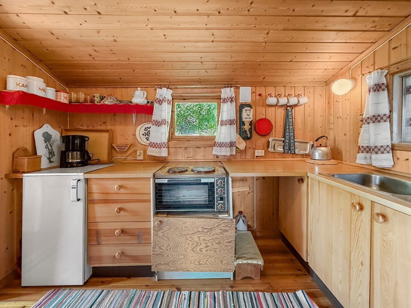 Kjøkkeninnredning med enkel standard. Fronter i finèr. Laminat benkeplate med utslagsvask i stål. Benk med plass for hybelkomfyr, samt plass for lite kjøleskap Galleribilde