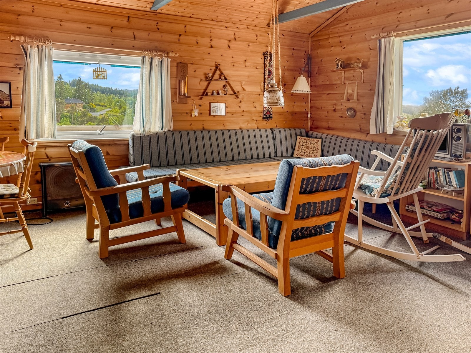 Stuen har teppe på gulv oppå linoleumsbelegg. Tradisjonelt panel på vegger Galleribilde